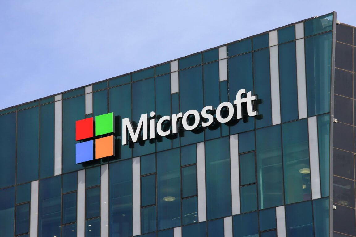 The Microsoft logo and name mounted on the glass facade of an office building