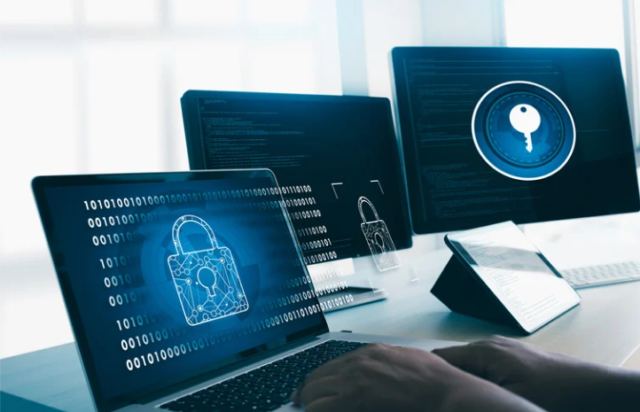 Person working on a laptop with cybersecurity visuals, including a padlock symbol on the screen, representing 24/7 managed SOC and threat detection